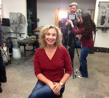 Dr. Sandra Alfoldy, sitting on stool, looking straight ahead into camera.