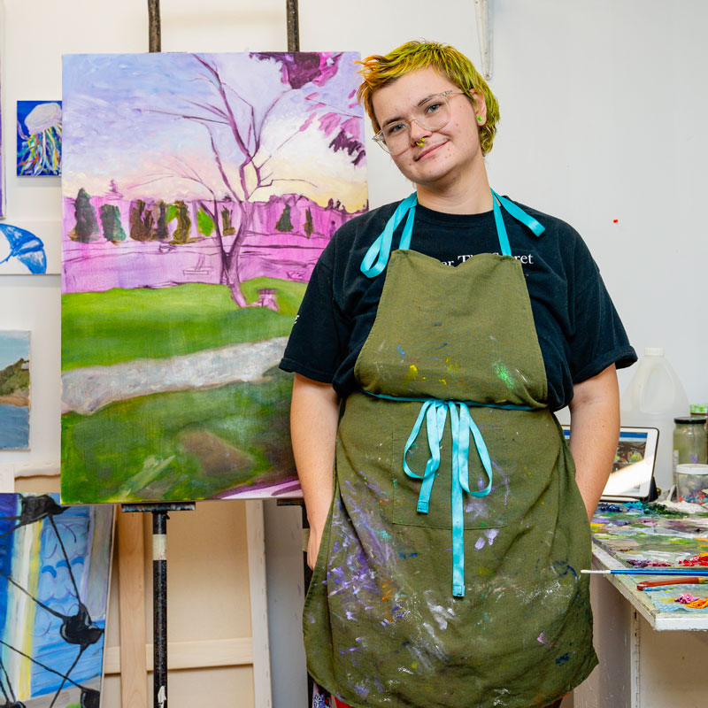painting student standing in front of an easel