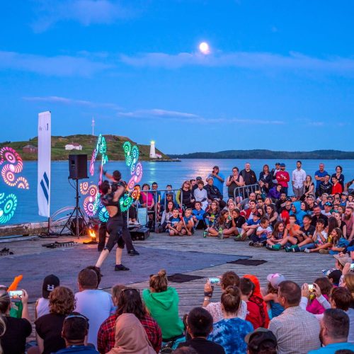 Crowd gathered for a busker show on the Halifax waterfront at dusk