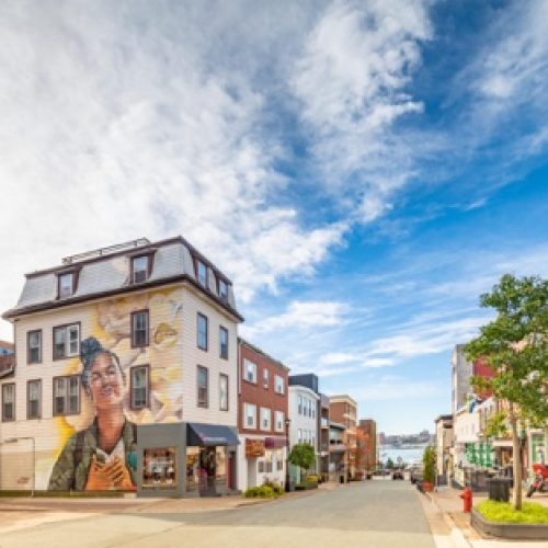 Street corner with a large portrait mural on a building in Halifax